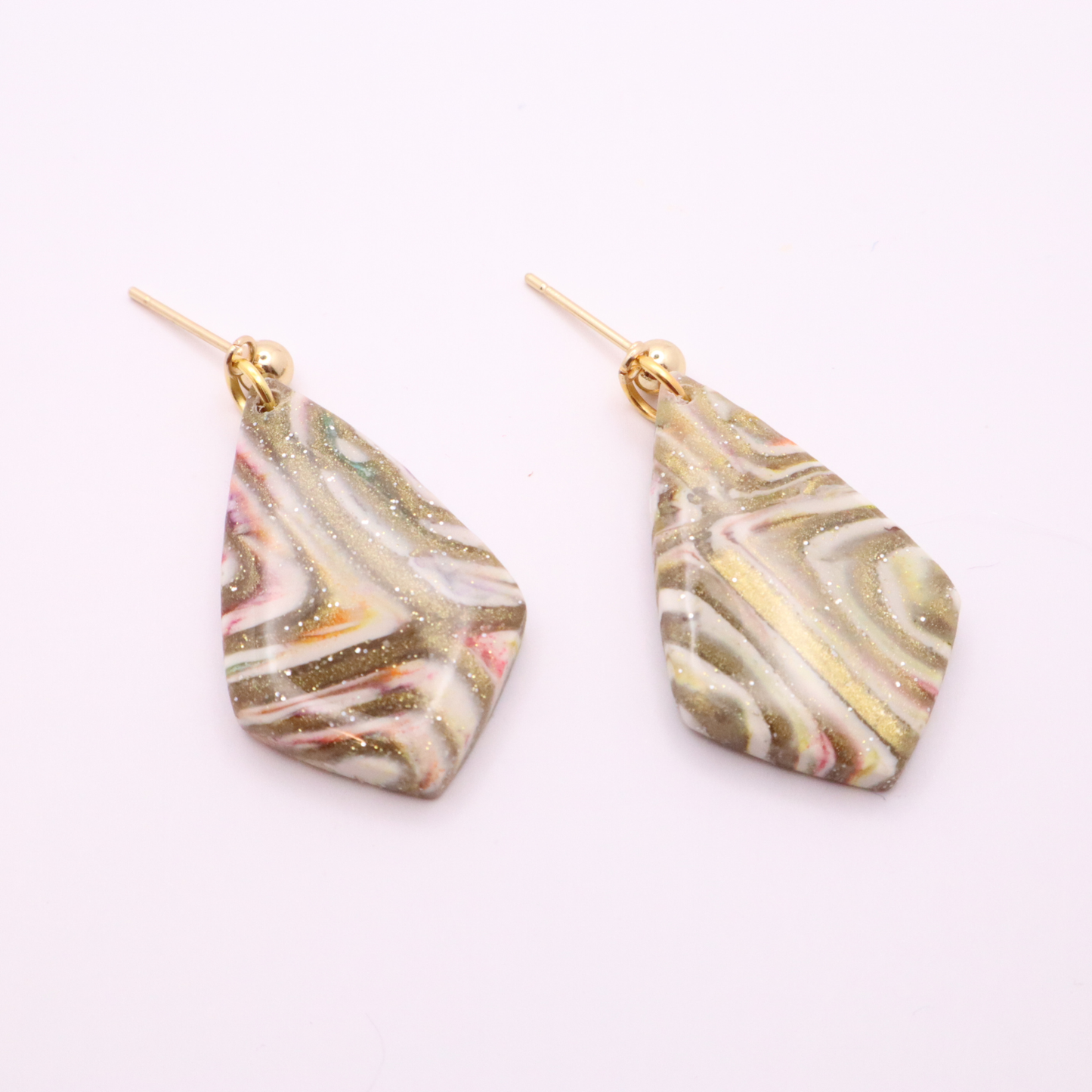 Handmade geometric polymer clay earrings in neutral marbled tones with subtle sparkle and stainless steel stud posts