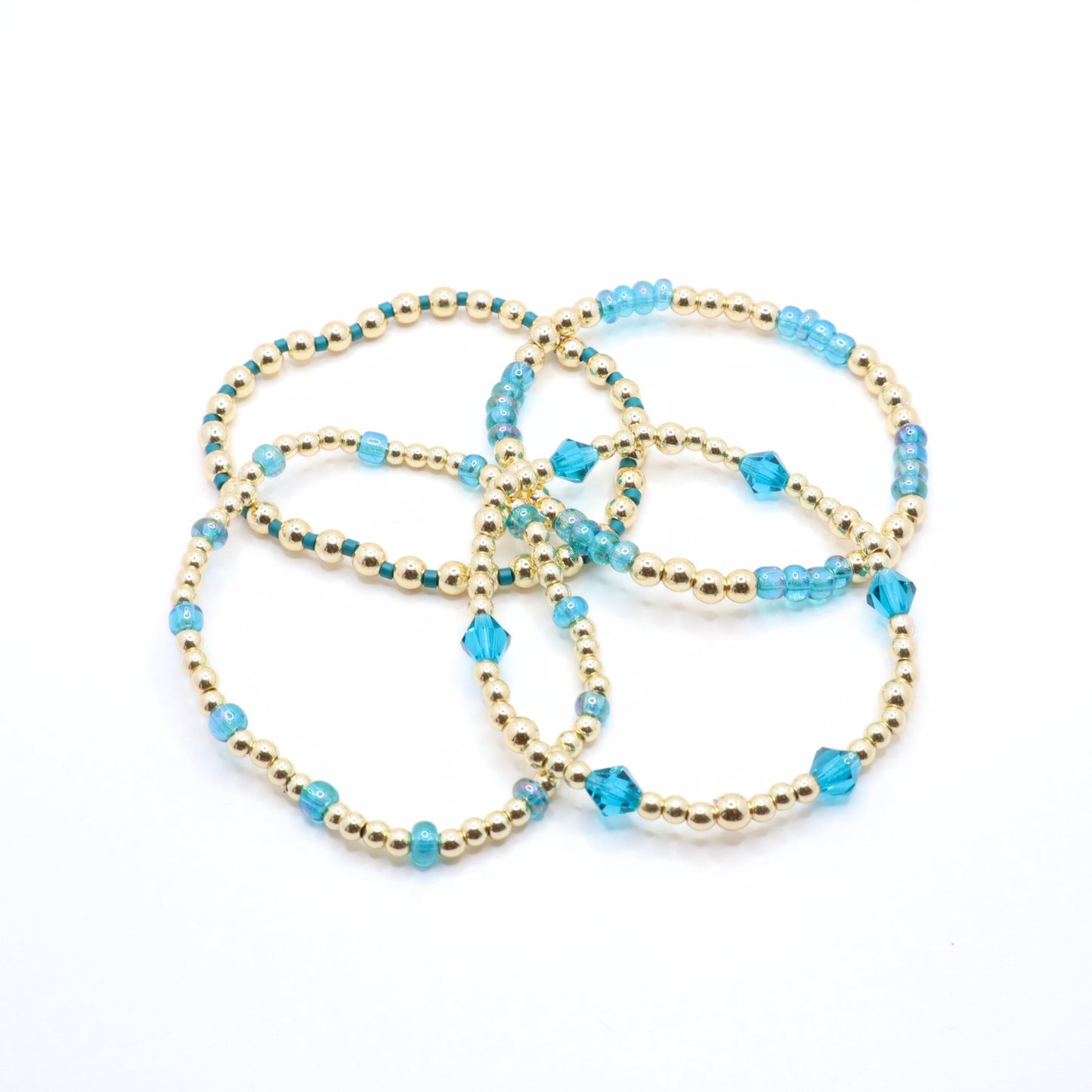 Blue crystal and gold bead bracelet trio styled as a layered stack.