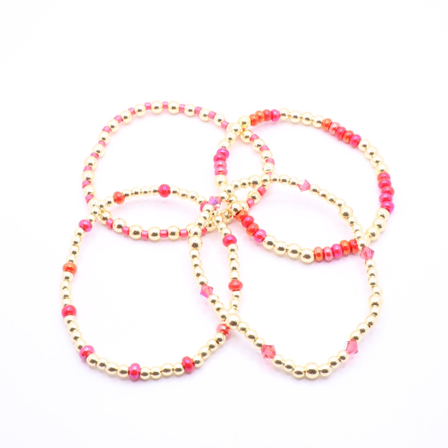 Feminine pink and coral stretch bracelet set with crystal details.