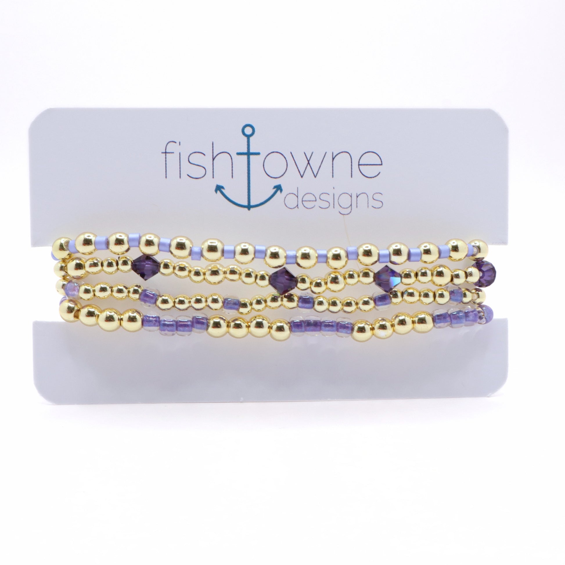 Handmade Lavender Tides bracelet stack featuring gold-tone beads, lavender seed beads, and purple crystal accents displayed on a jewelry card.