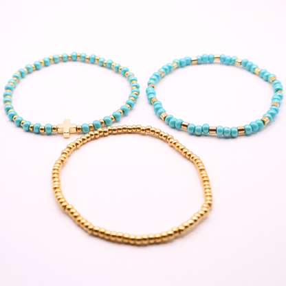Three bracelets with turquoise beads and gold accents on a white background