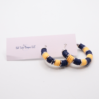 Handmade navy and gold polymer clay heishi bead hoop earrings with gold spacers shown on a white background with display card