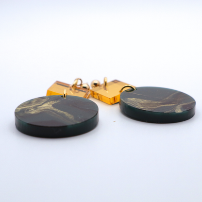 Green and gold marbled earrings on a white background