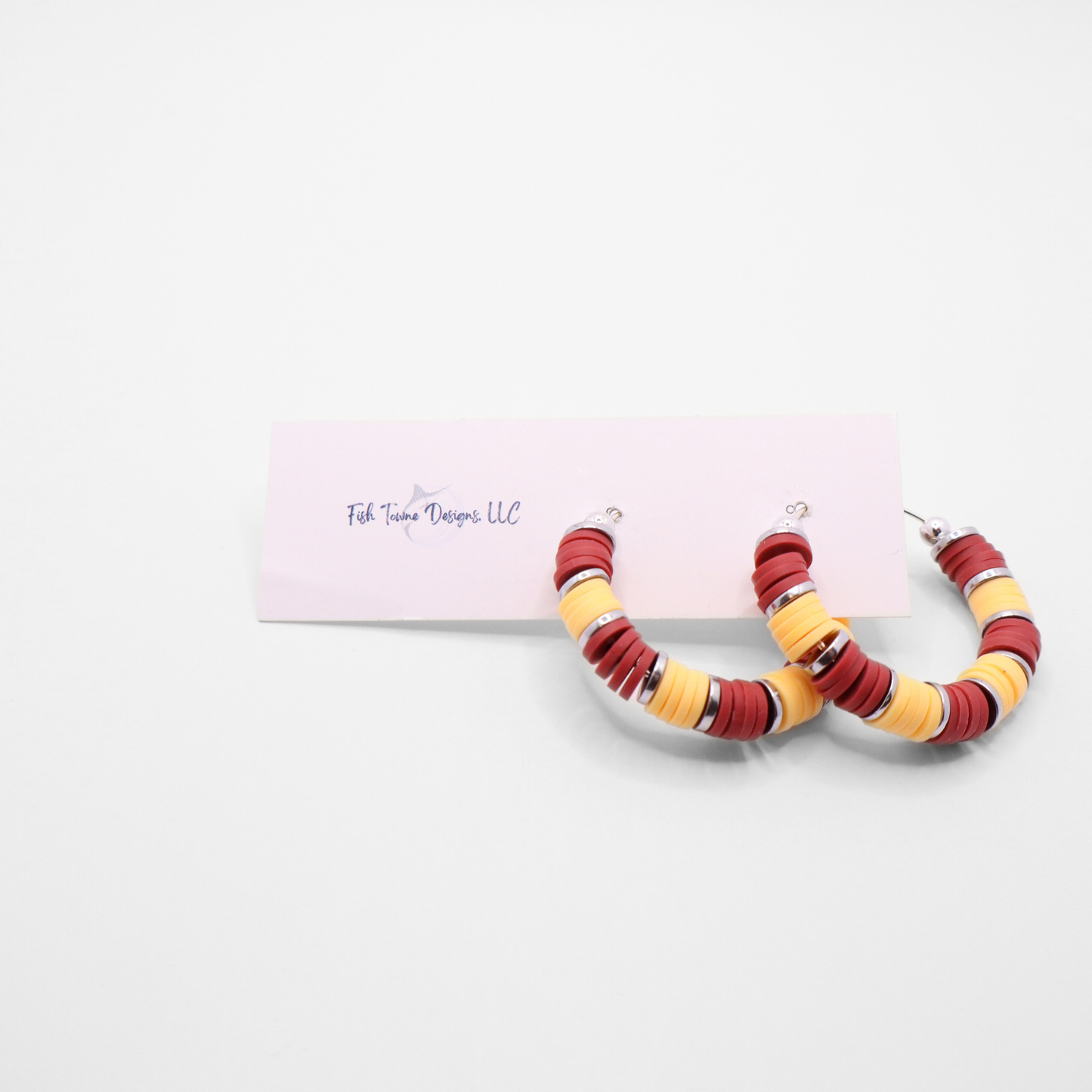 Handmade burgundy and gold polymer clay heishi bead hoop earrings with gold spacers shown on a white background with display card