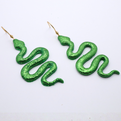 Green snake-shaped earrings on a white background
