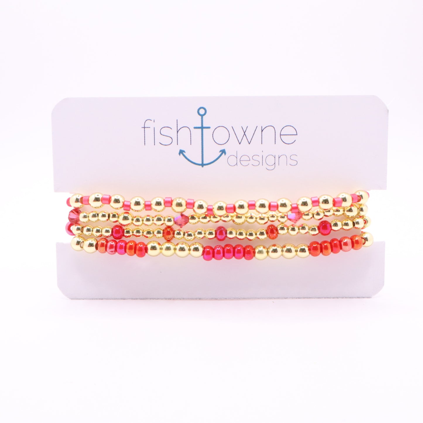 Four-piece pink and coral bracelet stack with gold hematite beads and crystal accents.