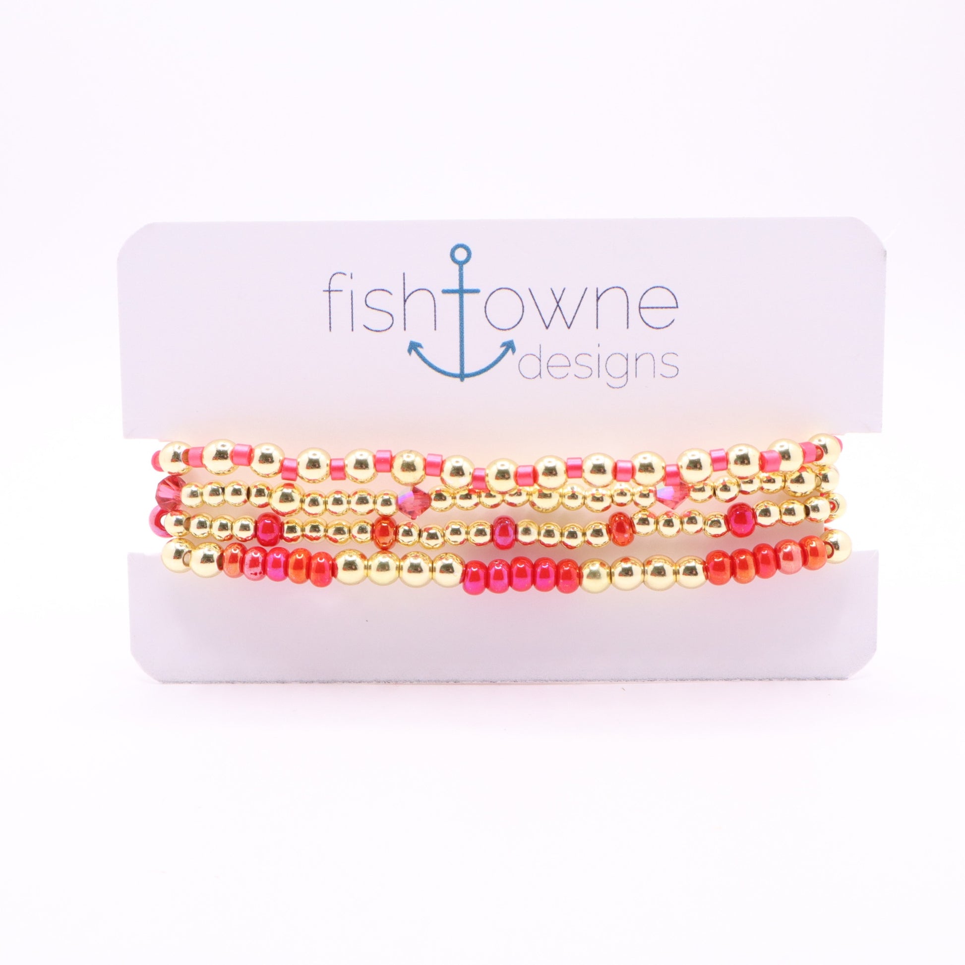 Four-piece pink and coral bracelet stack with gold hematite beads and crystal accents.
