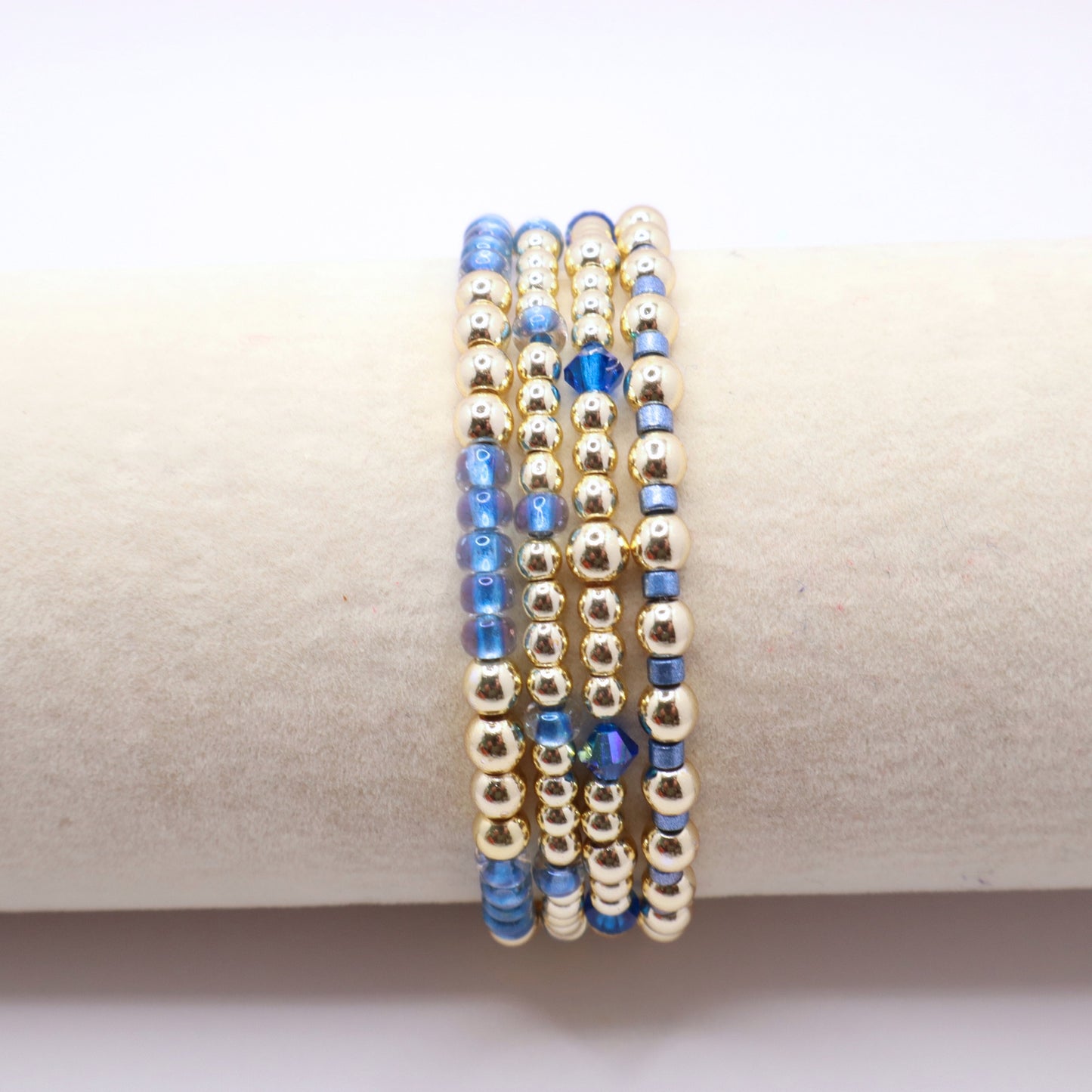 Handmade four bracelet set featuring gold-tone hematite beads and blue seed beads.