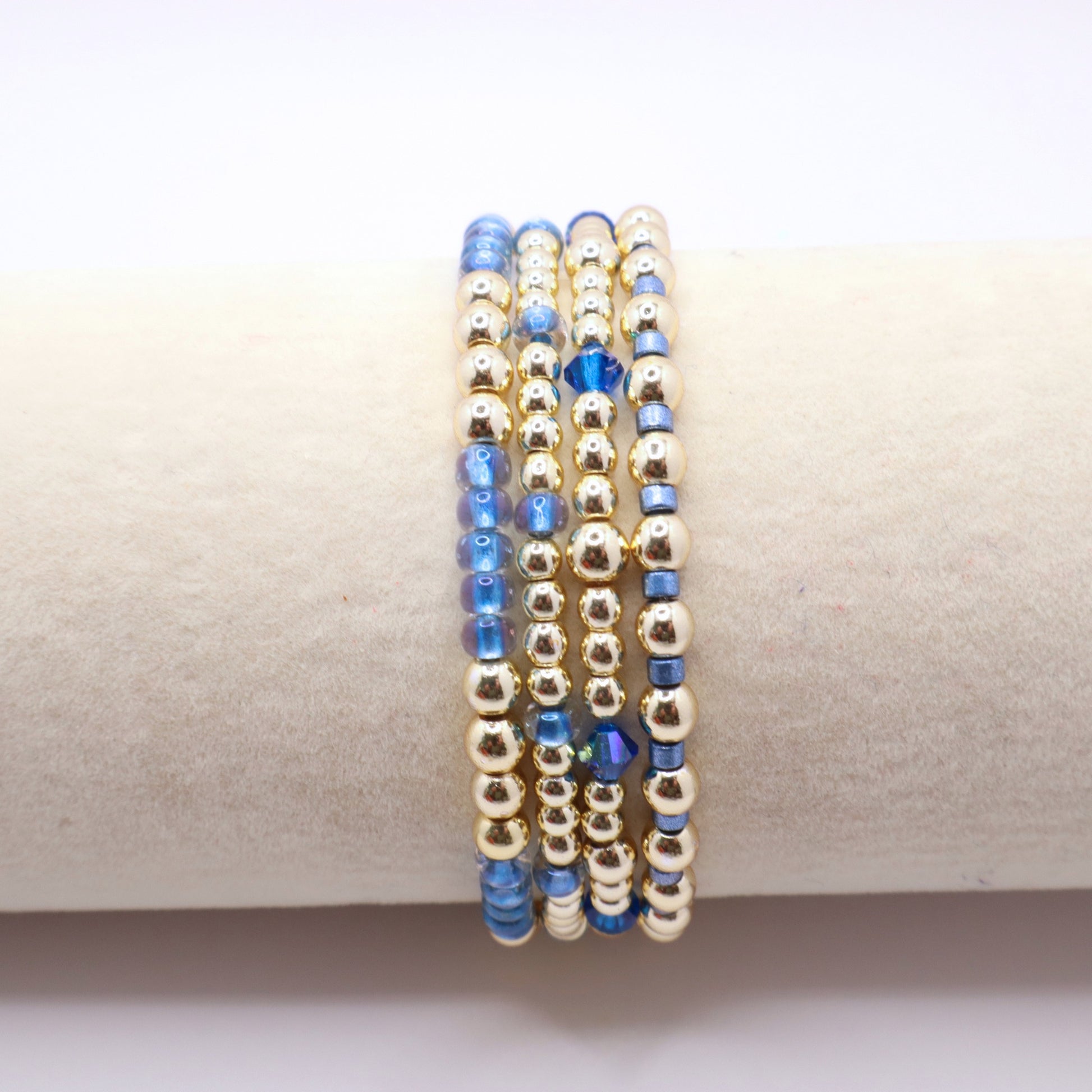 Handmade four bracelet set featuring gold-tone hematite beads and blue seed beads.