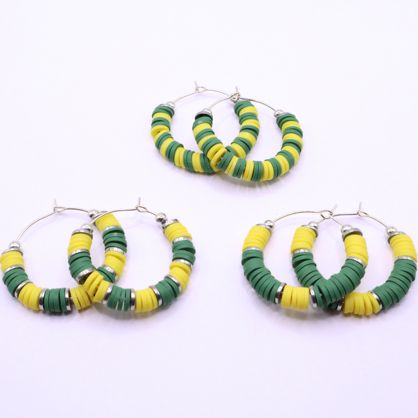 Set of three green and yellow heishi bead hoop earring styles arranged on a white background, showcasing size and pattern variations