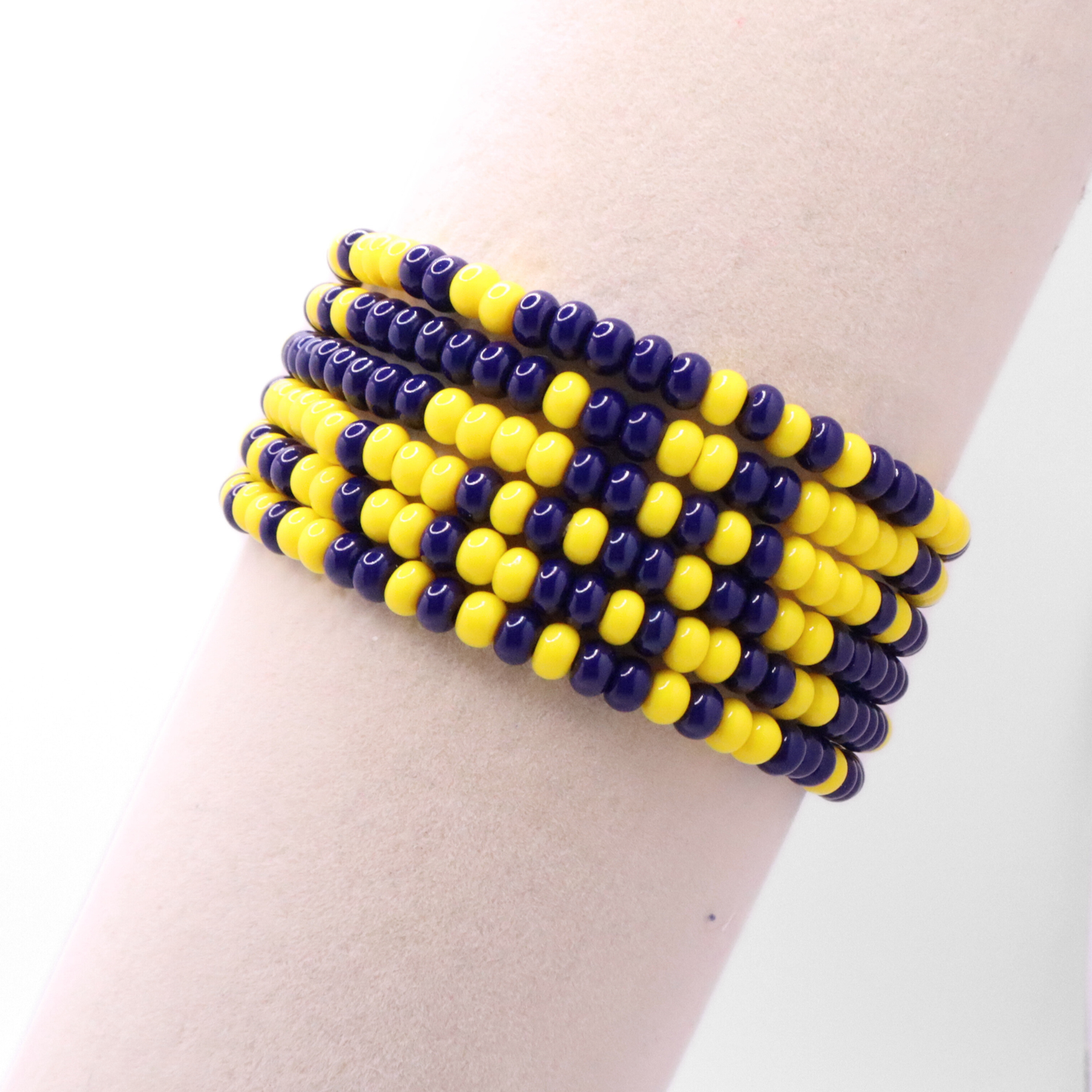 Set of six navy blue and yellow seed bead stretch bracelets featuring random navy blue and yellow seed beads on a white background