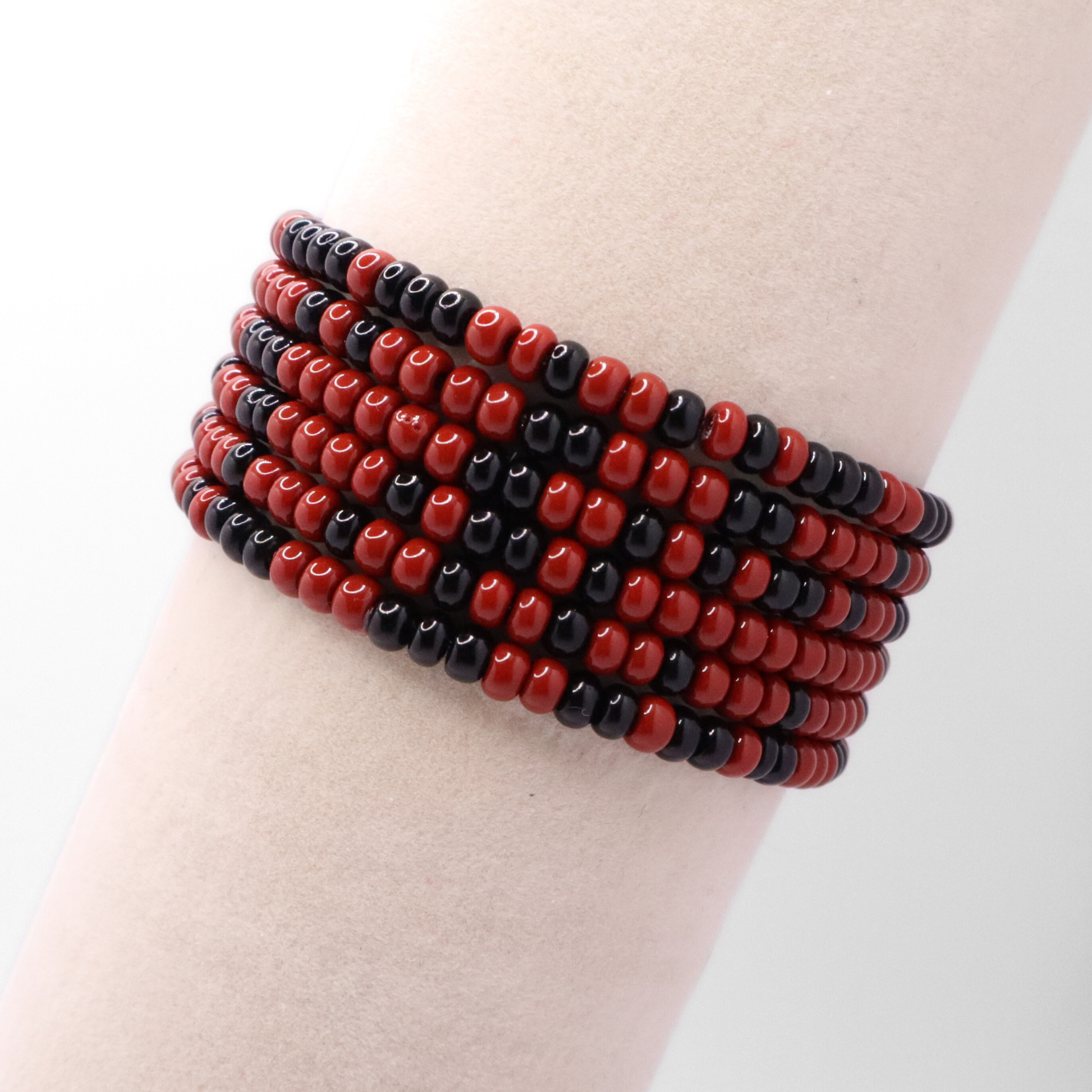 Set of six maroon and black seed bead stretch bracelets featuring random maroon and black seed beads on a white background