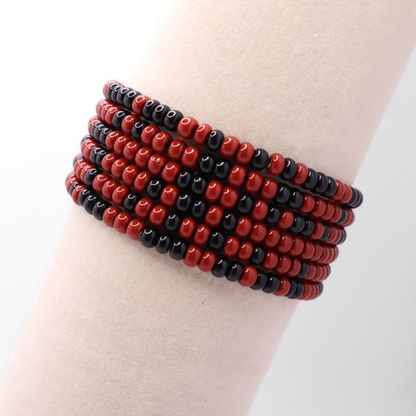 Set of six maroon and black seed bead stretch bracelets featuring random maroon and black seed beads on a white background