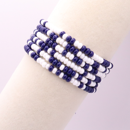 Set of six navy blue and white seed bead stretch bracelets featuring random navy blue and white seed beads on a white background