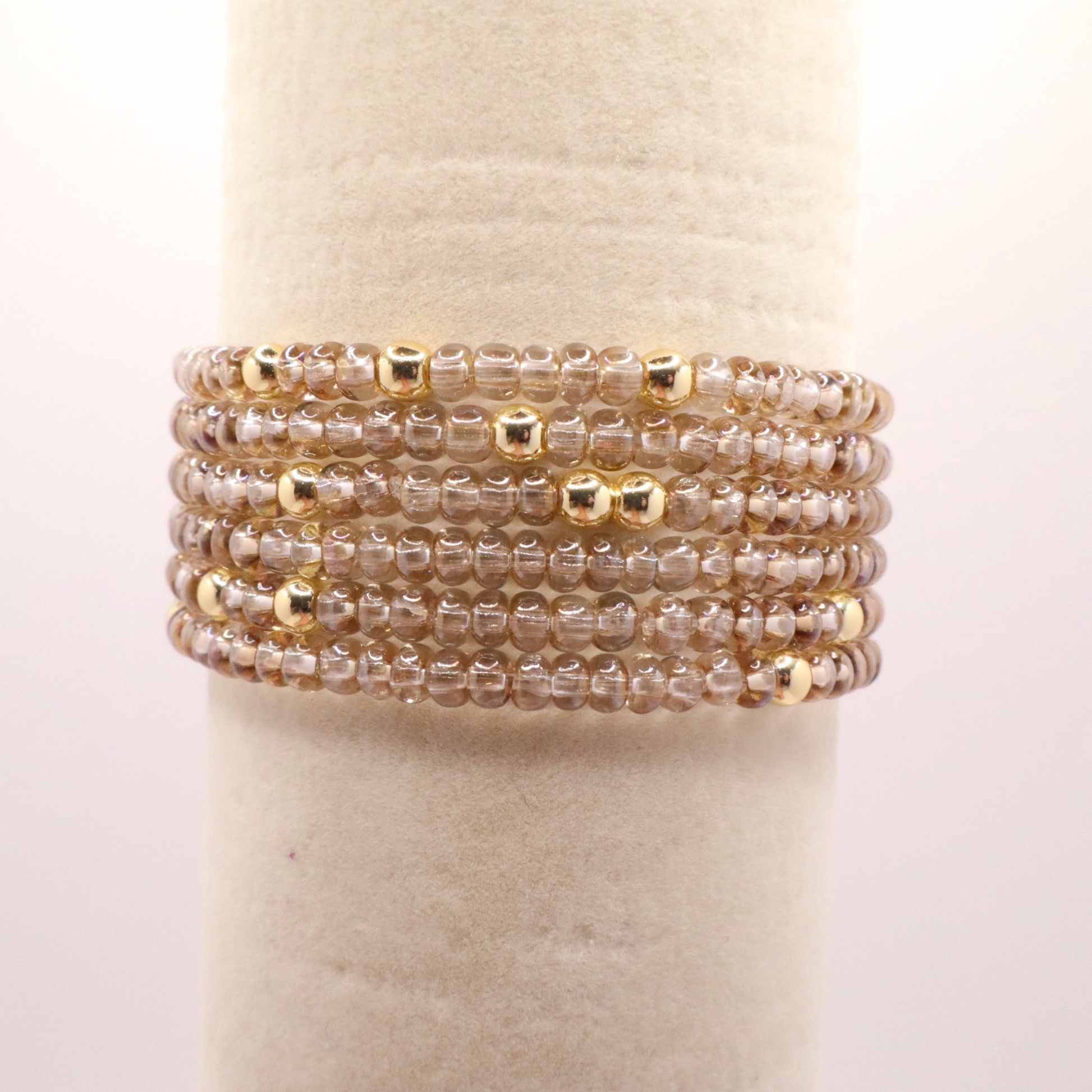 set of six neutral gold tone seed bead bracelets featuring high quality neutral seed beads and golden hematite accent beads.  The stack is displayed on a white background.