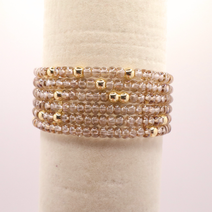 set of six neutral gold tone seed bead bracelets featuring high quality neutral seed beads and golden hematite accent beads.  The stack is displayed on a white background.