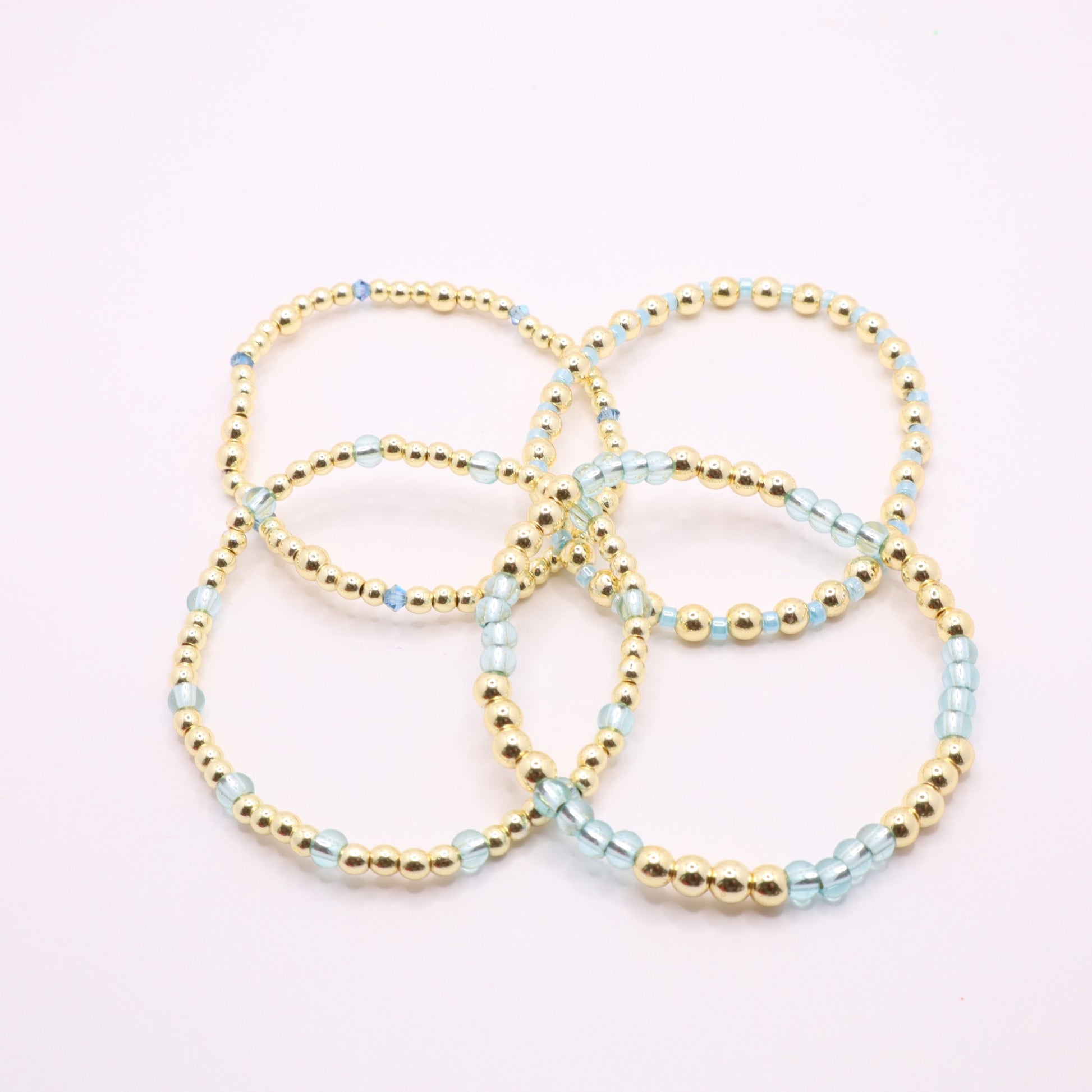 Blue and gold bracelet stack styled together for an elegant layered jewelry look.