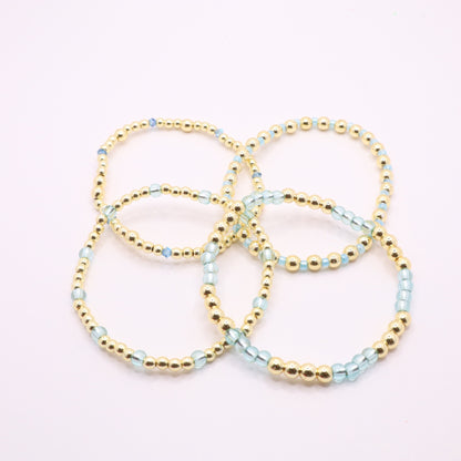 Blue and gold bracelet stack styled together for an elegant layered jewelry look.