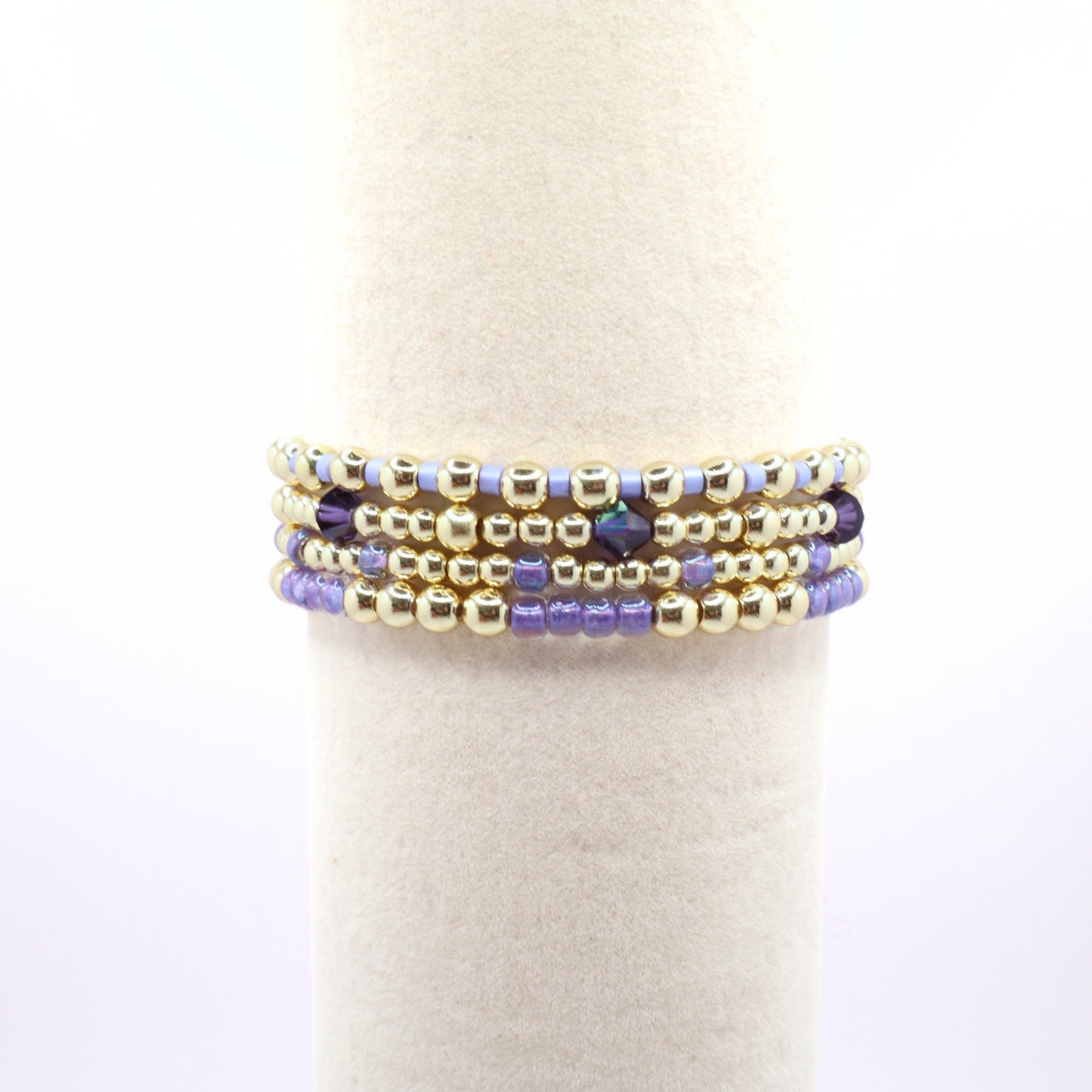 Purple and gold beaded bracelet set featuring crystal accents and coastal-inspired colors.