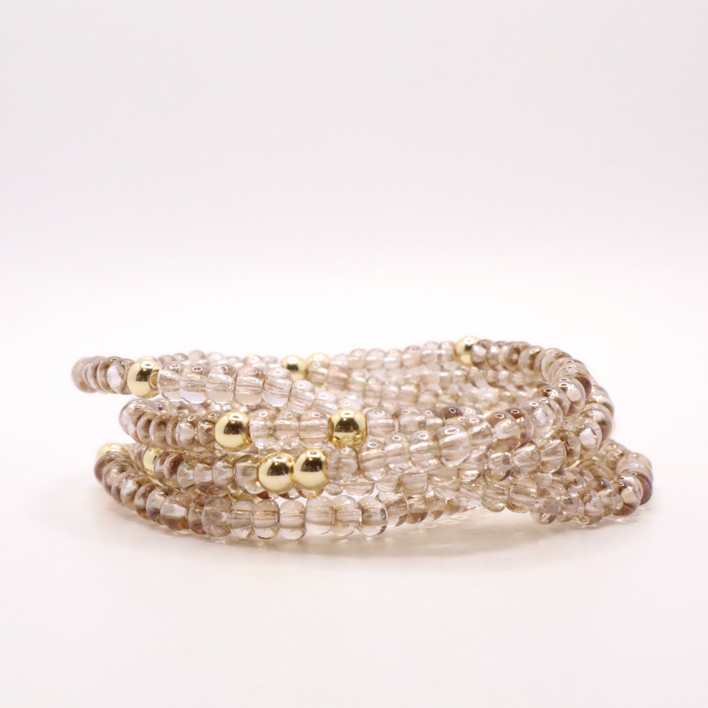 set of six neutral gold tone seed bead bracelets featuring high quality neutral seed beads and golden hematite accent beads.  The stack is displayed on a white background.