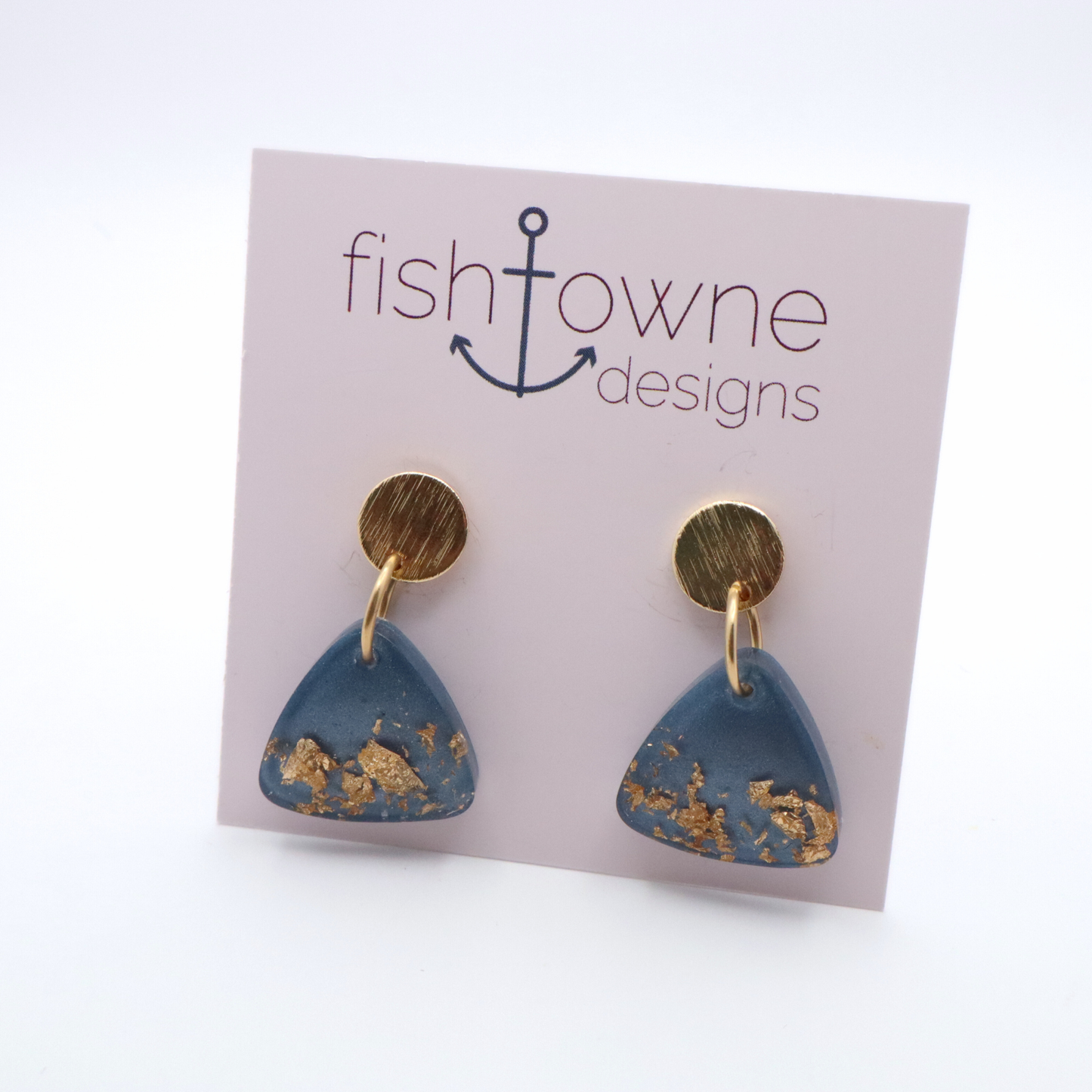 Blue and gold earrings on a Fish Towne Designs card against a white background