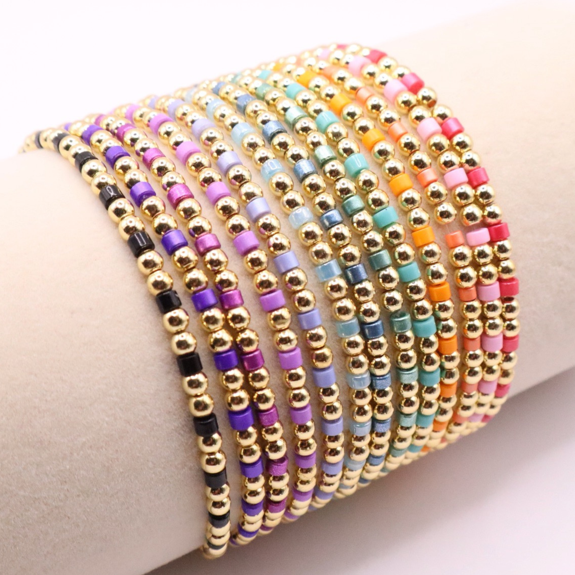Set of 18K gold filled beaded stretch bracelets featuring vibrant multicolor seed bead accents, stacked on a display for a bright, layered look.