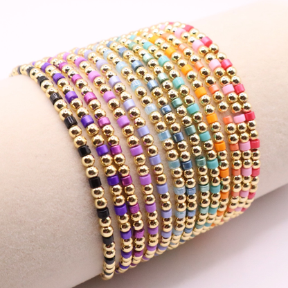 Set of 18K gold filled beaded stretch bracelets featuring vibrant multicolor seed bead accents, stacked on a display for a bright, layered look.