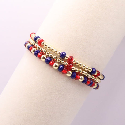 Three blue, red, and gold bracelets on a bracelet display