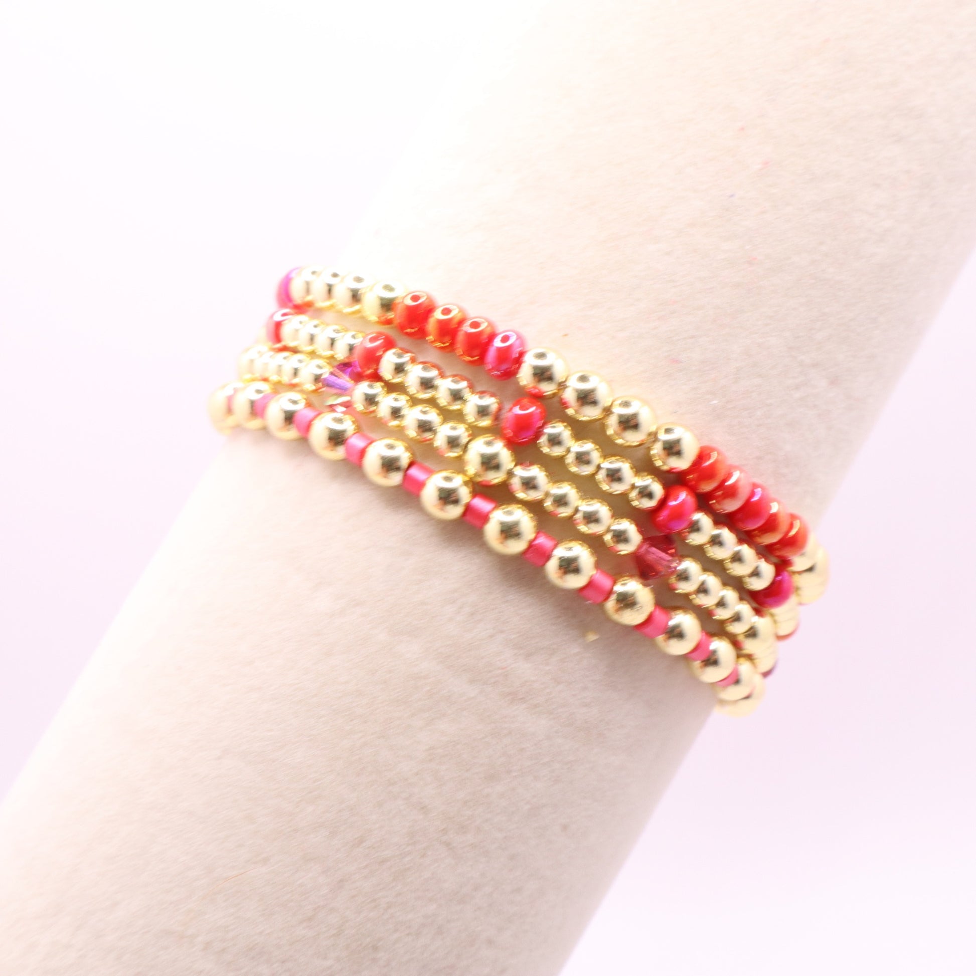 Layered bracelet set with hot pink, coral, gold hematite, and crystal accents.