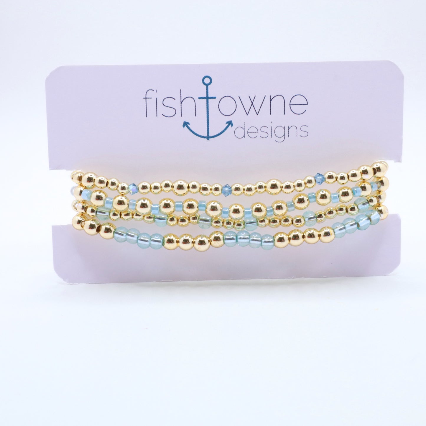 Three-piece sky blue hematite bracelet stack featuring gold-tone beads and translucent blue glass accents.