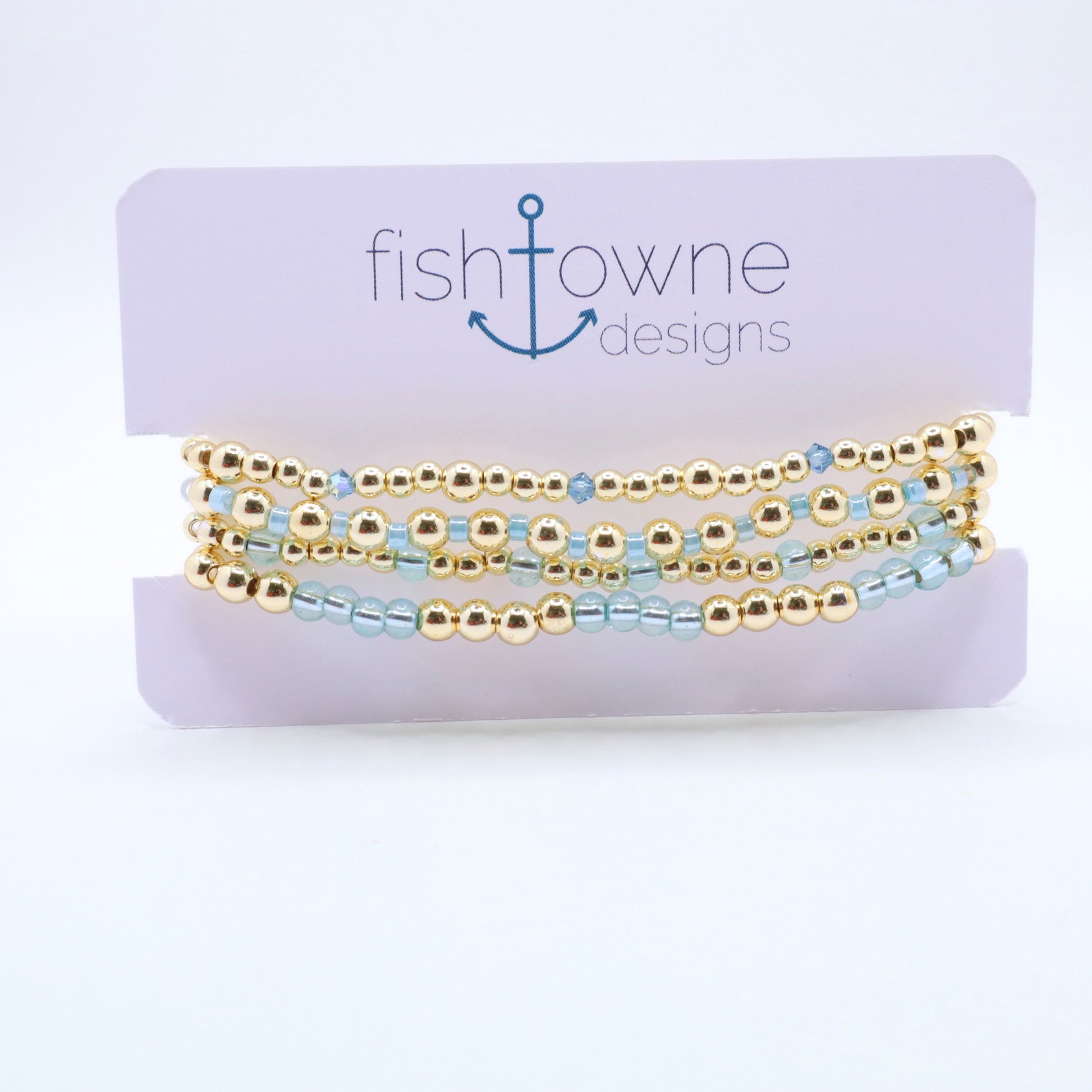 Three-piece sky blue hematite bracelet stack featuring gold-tone beads and translucent blue glass accents.