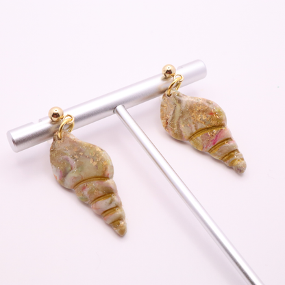 Seashell drop earrings with gold stud tops displayed on a minimalist jewelry stand