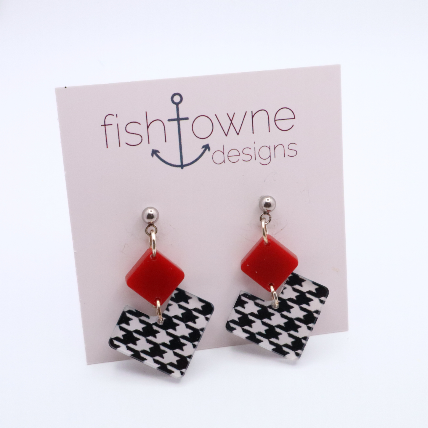 Pair of earrings with red square and houndstooth heart design on a Fish Towne Designs card.