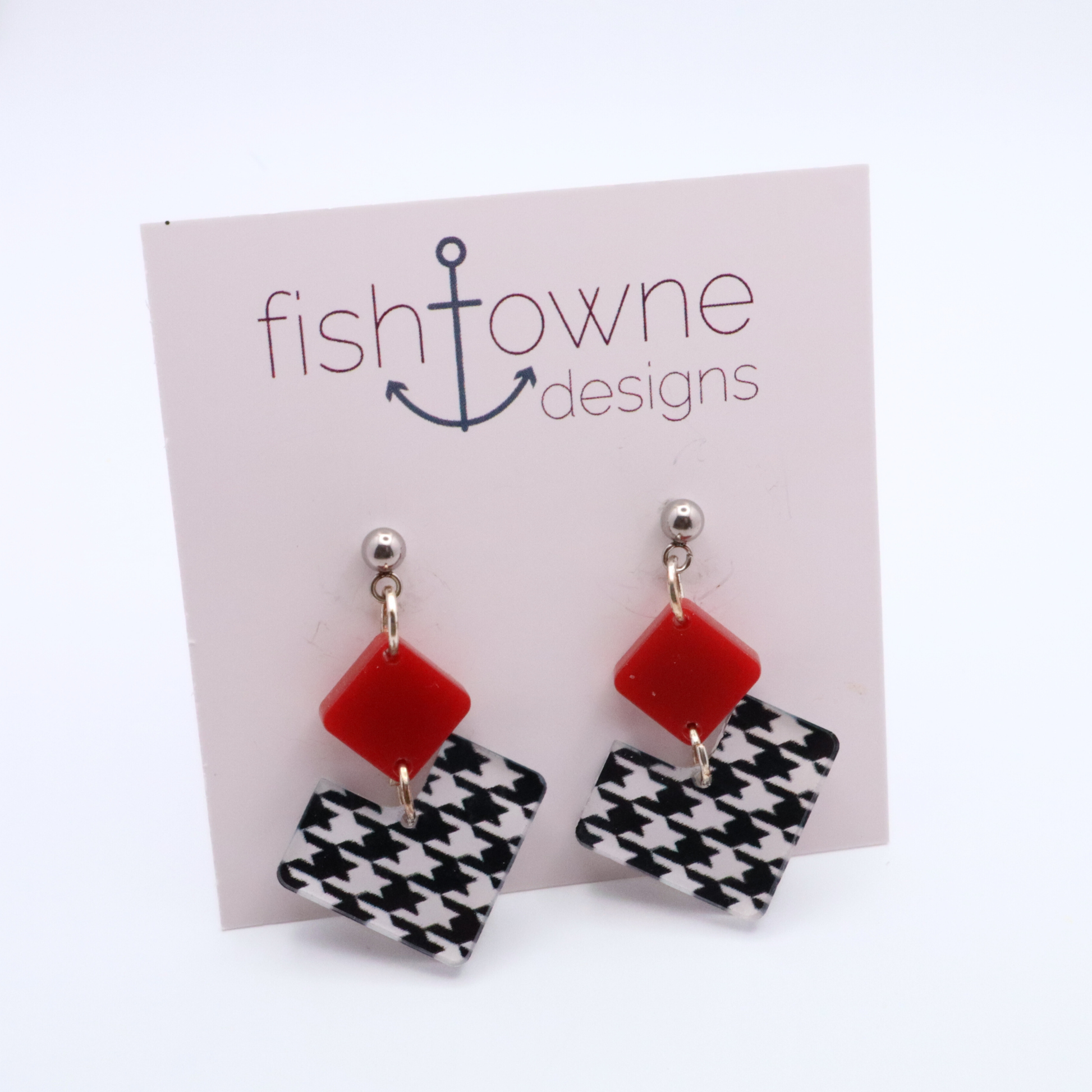 Pair of earrings with red square and houndstooth heart design on a Fish Towne Designs card.