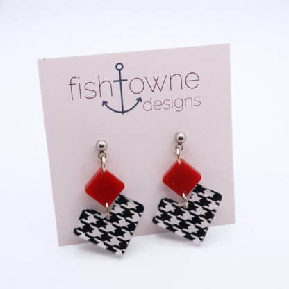Pair of earrings with red square and houndstooth heart design on a Fish Towne Designs card.