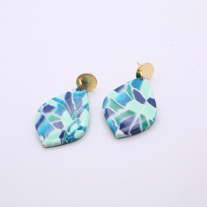 Close-up of mosaic patterned teardrop earrings in turquoise, navy, and mint with 18k gold plated studs on white background