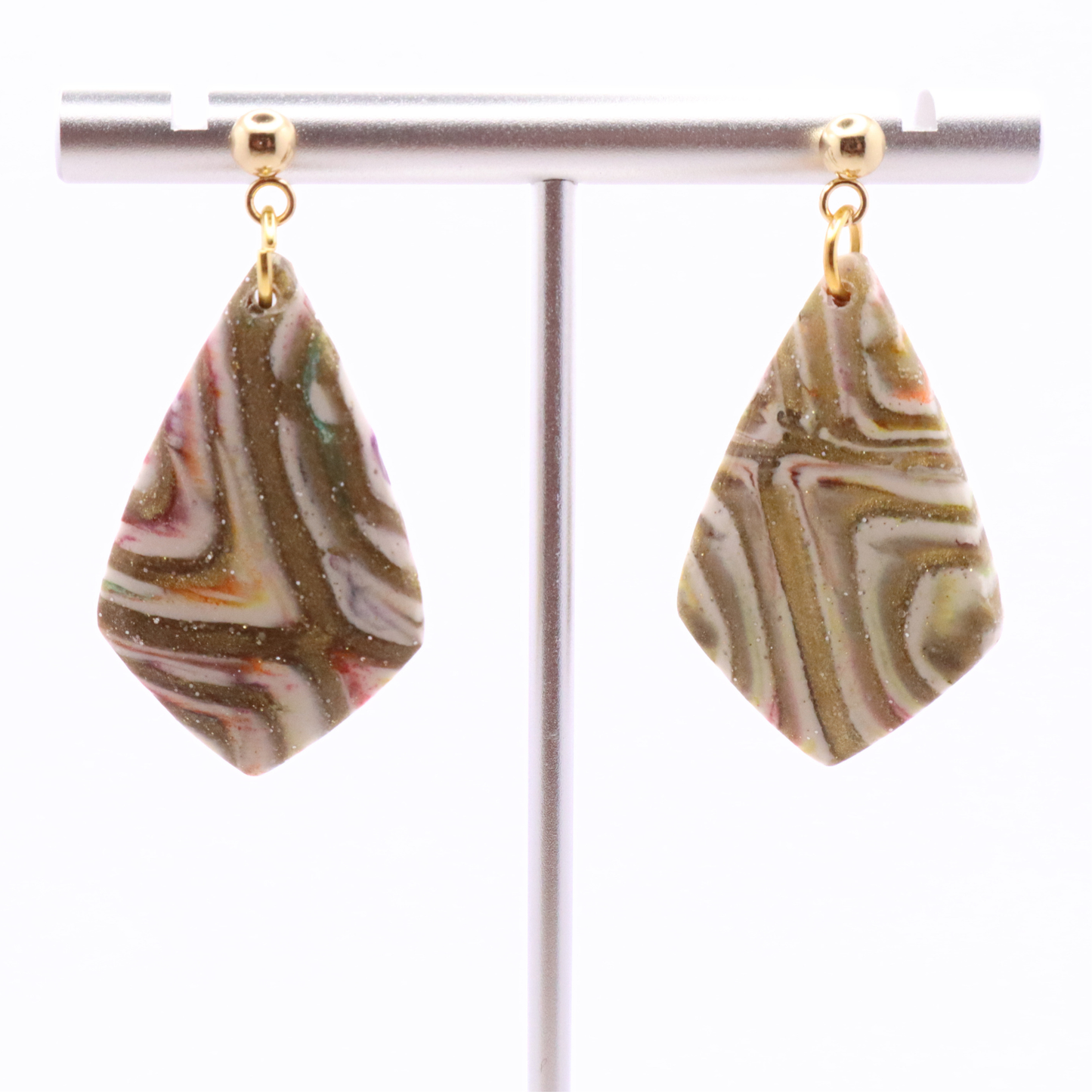 Neutral marbled clay statement earrings with gold detailing and stainless steel stud posts, shown on jewelry stand