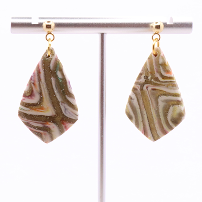 Neutral marbled clay statement earrings with gold detailing and stainless steel stud posts, shown on jewelry stand