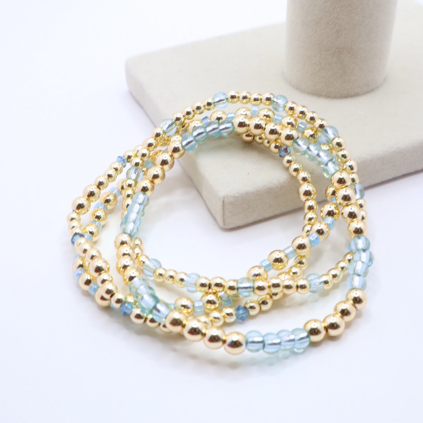 Gold hematite bracelet set accented with translucent blue beads and crystal details.
