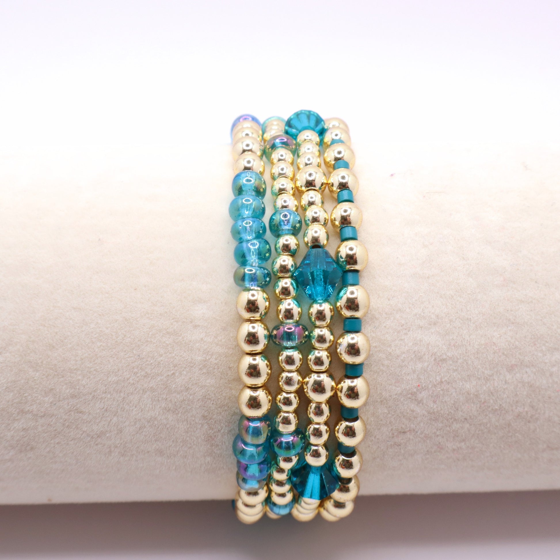 Gold hematite bracelets with soft blue seed beads and crystal details.