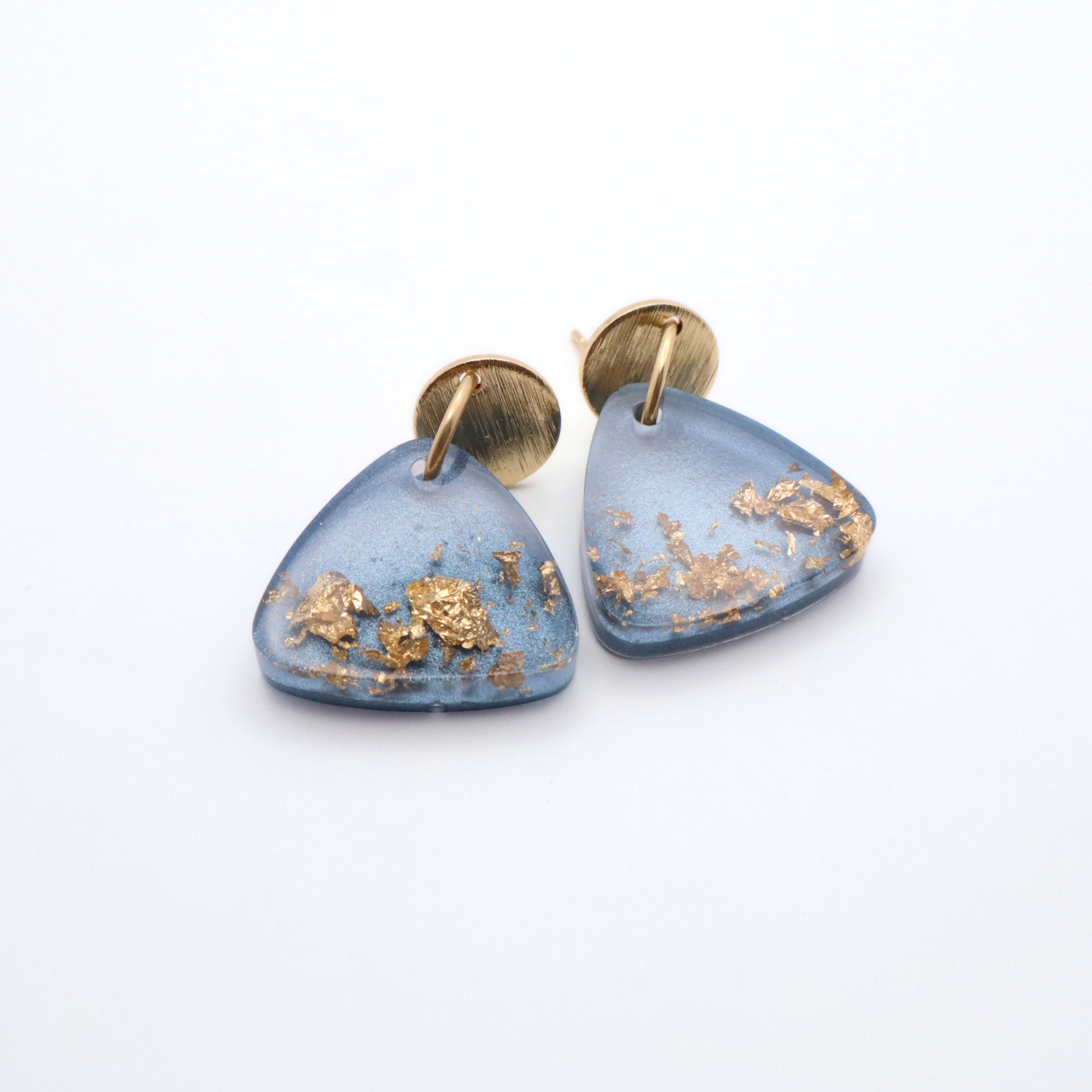 Denim blue triangular earrings with gold accents on a white background
