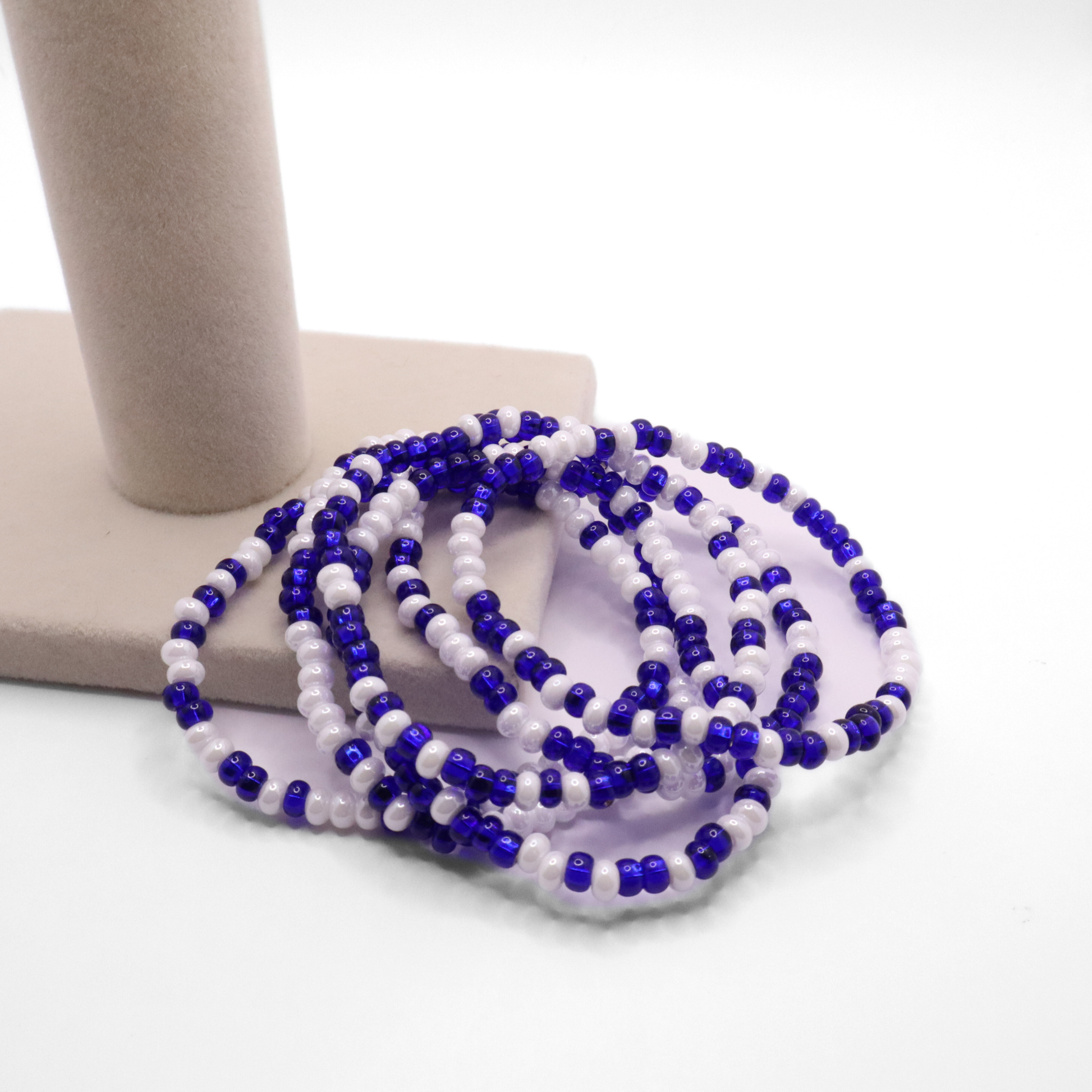 Set of six blue and white seed bead stretch bracelets featuring random blue and white seed beads on a white background
