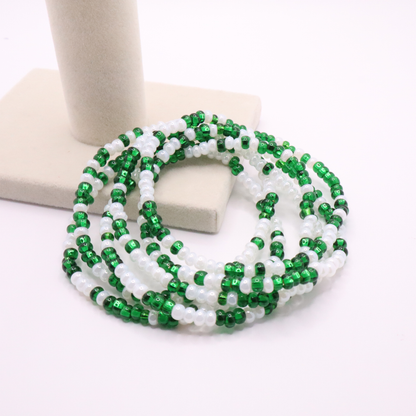 Set of six green and white seed bead stretch bracelets featuring random green and white seed beads on a white background