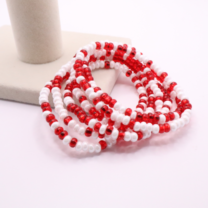 Set of six red and white seed bead stretch bracelets featuring random red and white seed beads on a white background