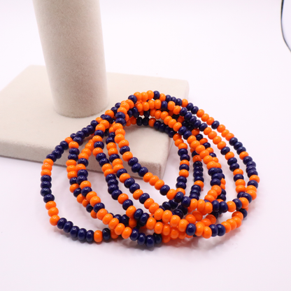 Set of six orange and navy blue seed bead stretch bracelets featuring random orange and navy blue seed beads on a white background