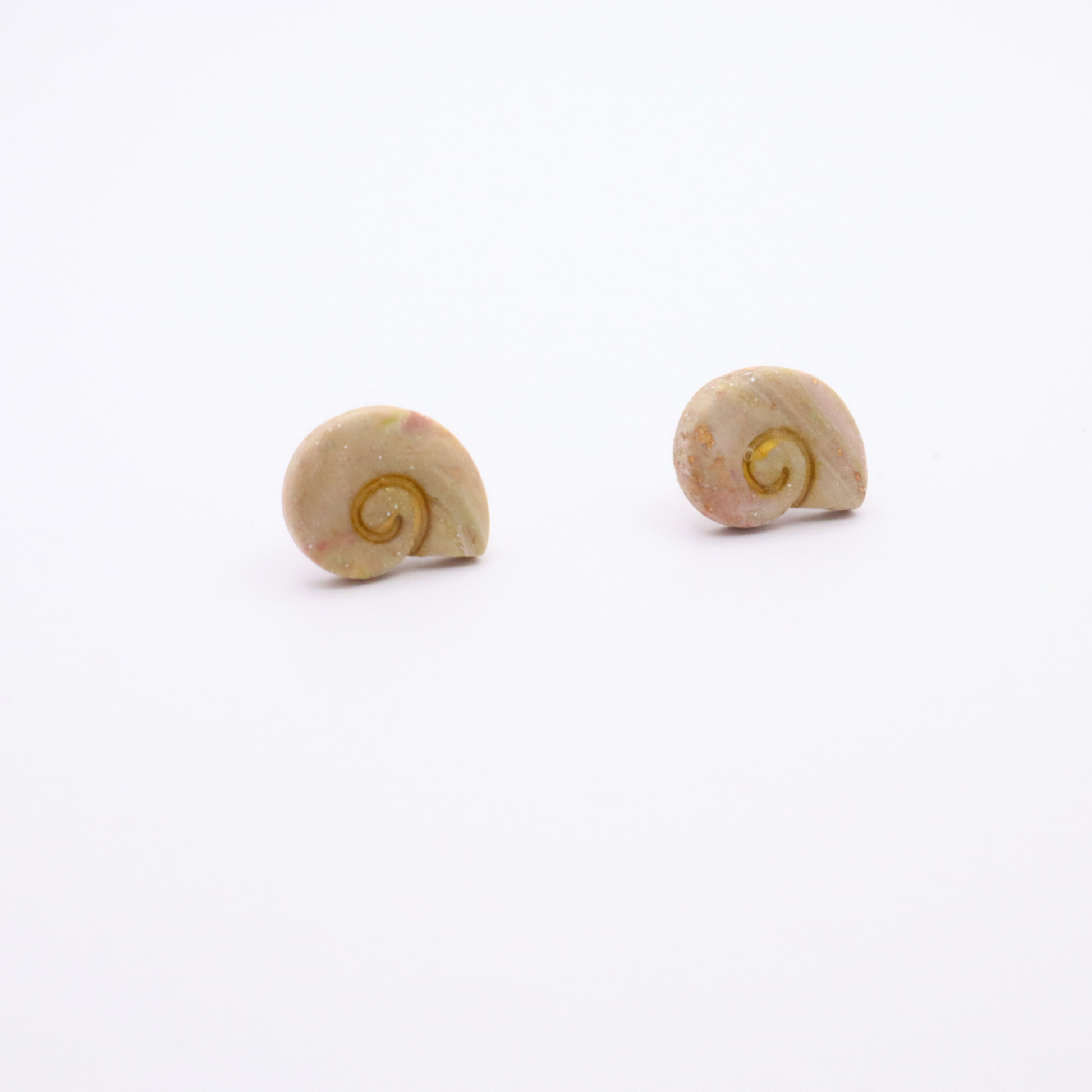 Coastal-inspired shell stud earrings with marbled finish and gold detailing on white background