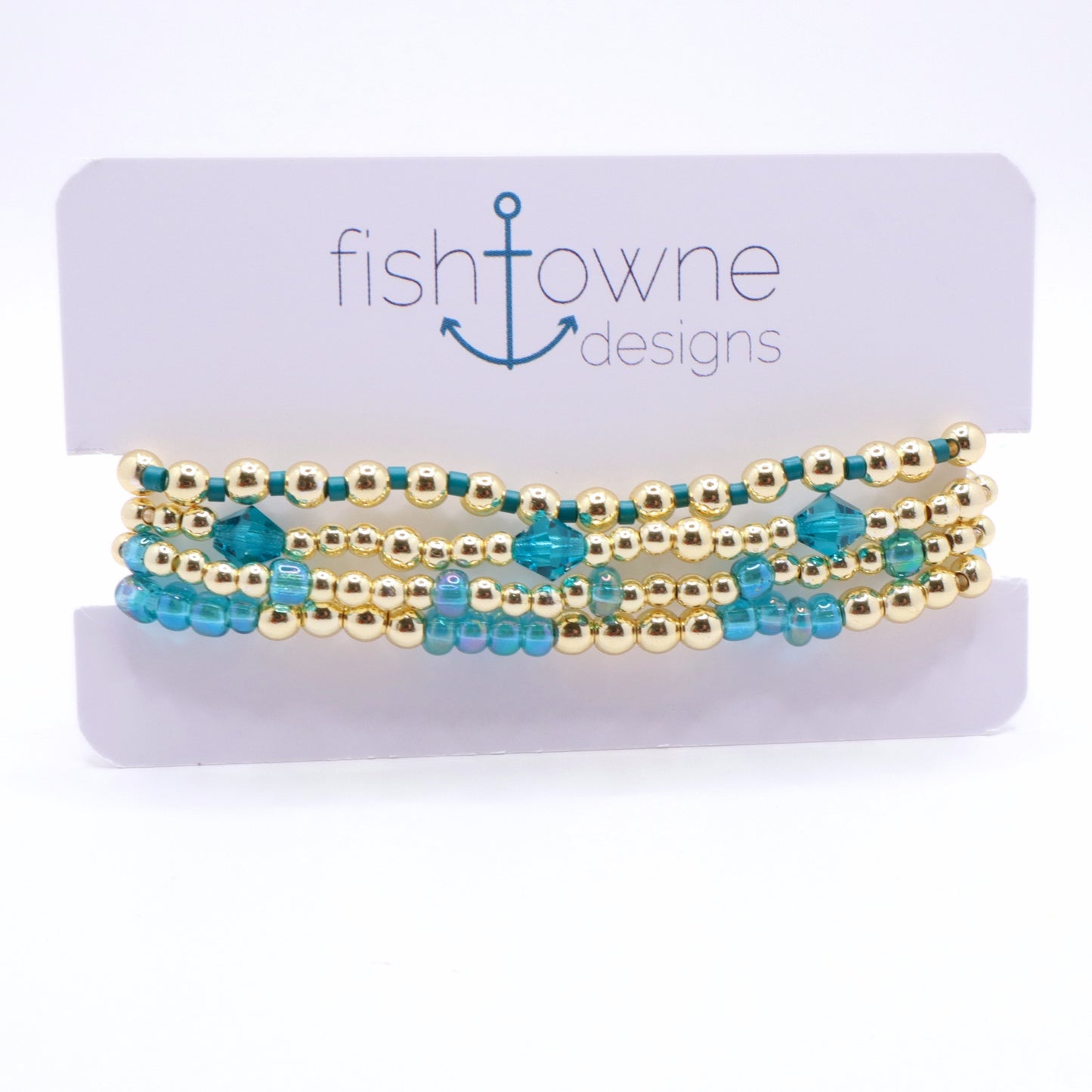 Layered periwinkle and gold bracelet stack displayed on a jewelry stand.