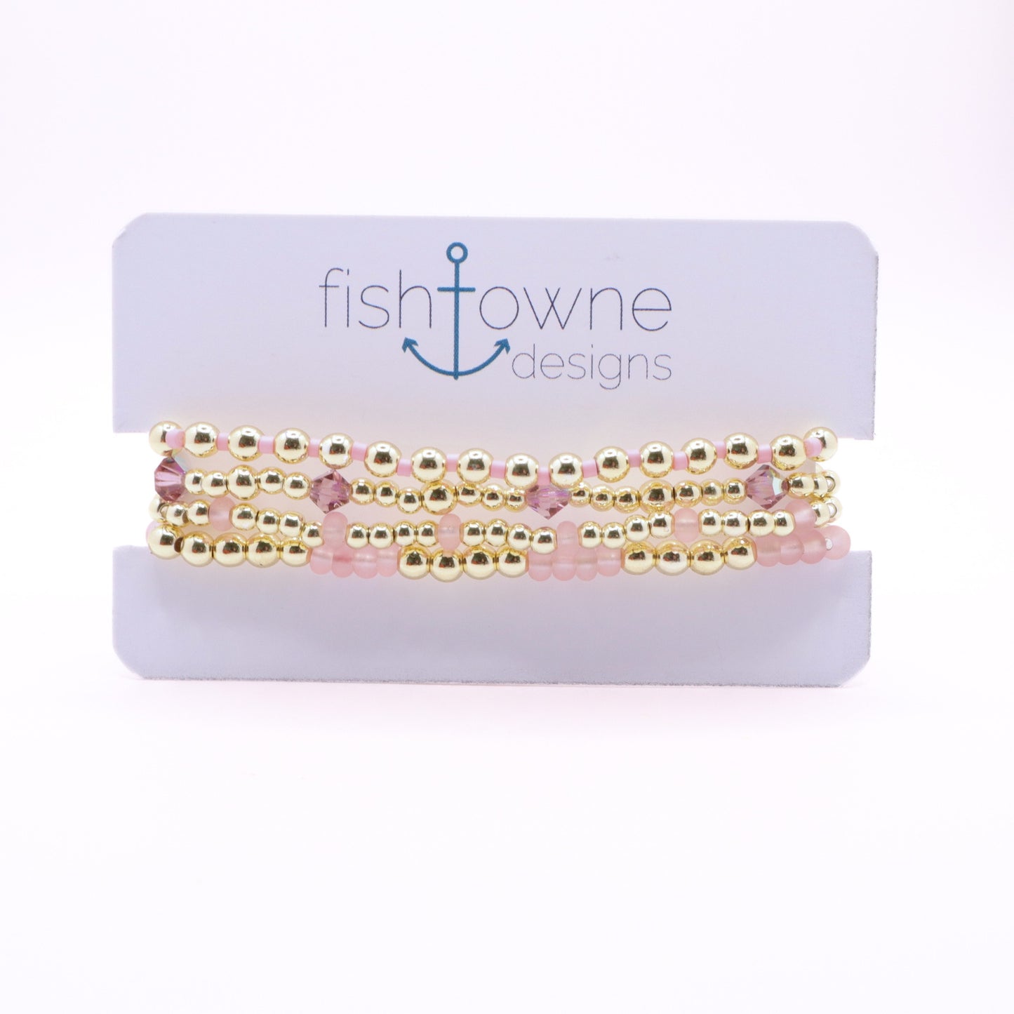 Four-piece blush pink and gold hematite bracelet stack with crystal accents.