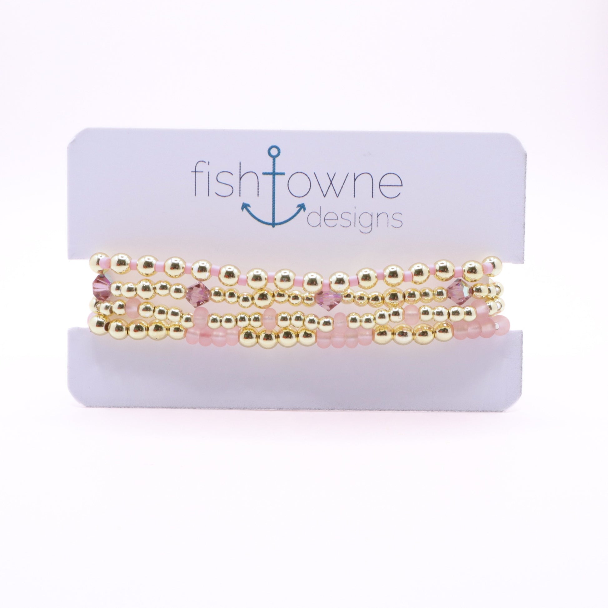 Four-piece blush pink and gold hematite bracelet stack with crystal accents.