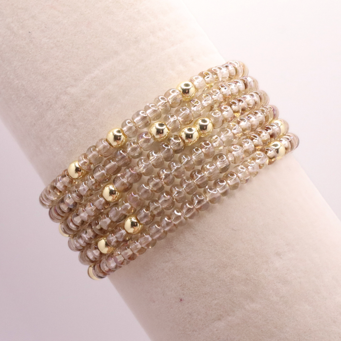 set of six neutral gold tone seed bead bracelets featuring high quality neutral seed beads and golden hematite accent beads.  The stack is displayed on a white background.